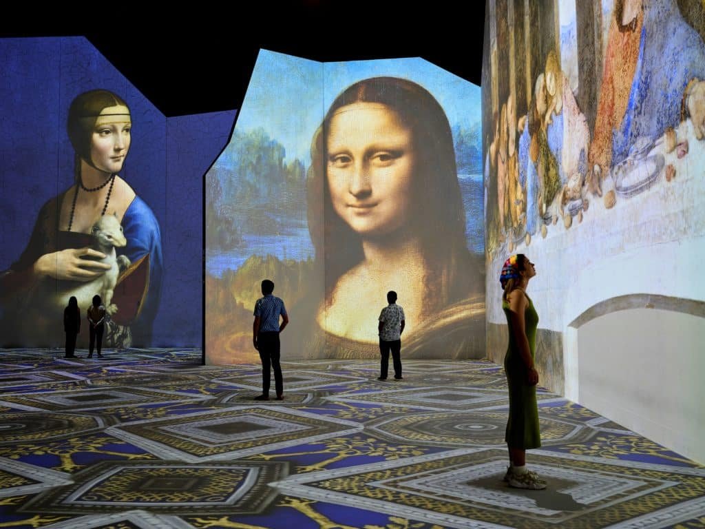 people looking at the Mona Lisa and other artworks by Leonardo da Vinci at The LUME