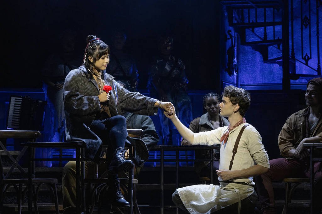 Orpheus kneeling in front of Eurydice in Hadestown
