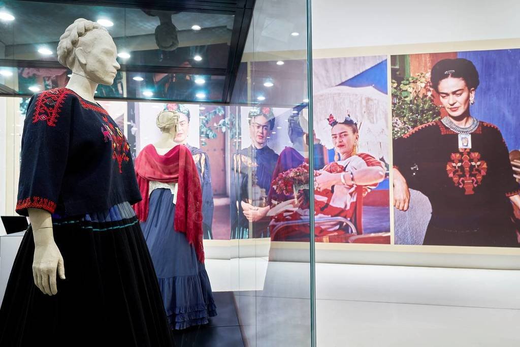 clothing and portraits on display in the Frida Kahlo exhibition